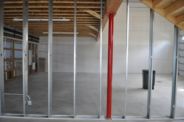 iron gate motor condos red pole under construction support beams wood work flooring ceiling